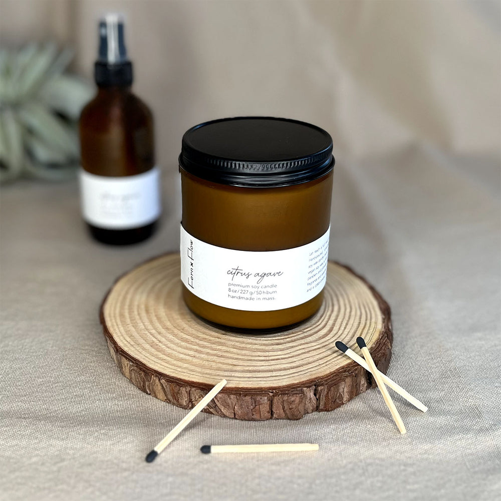 Fern x Flow Citrus Agave vegan soy candle and air + linen spray fragrance bundle on a rustic wooden riser.