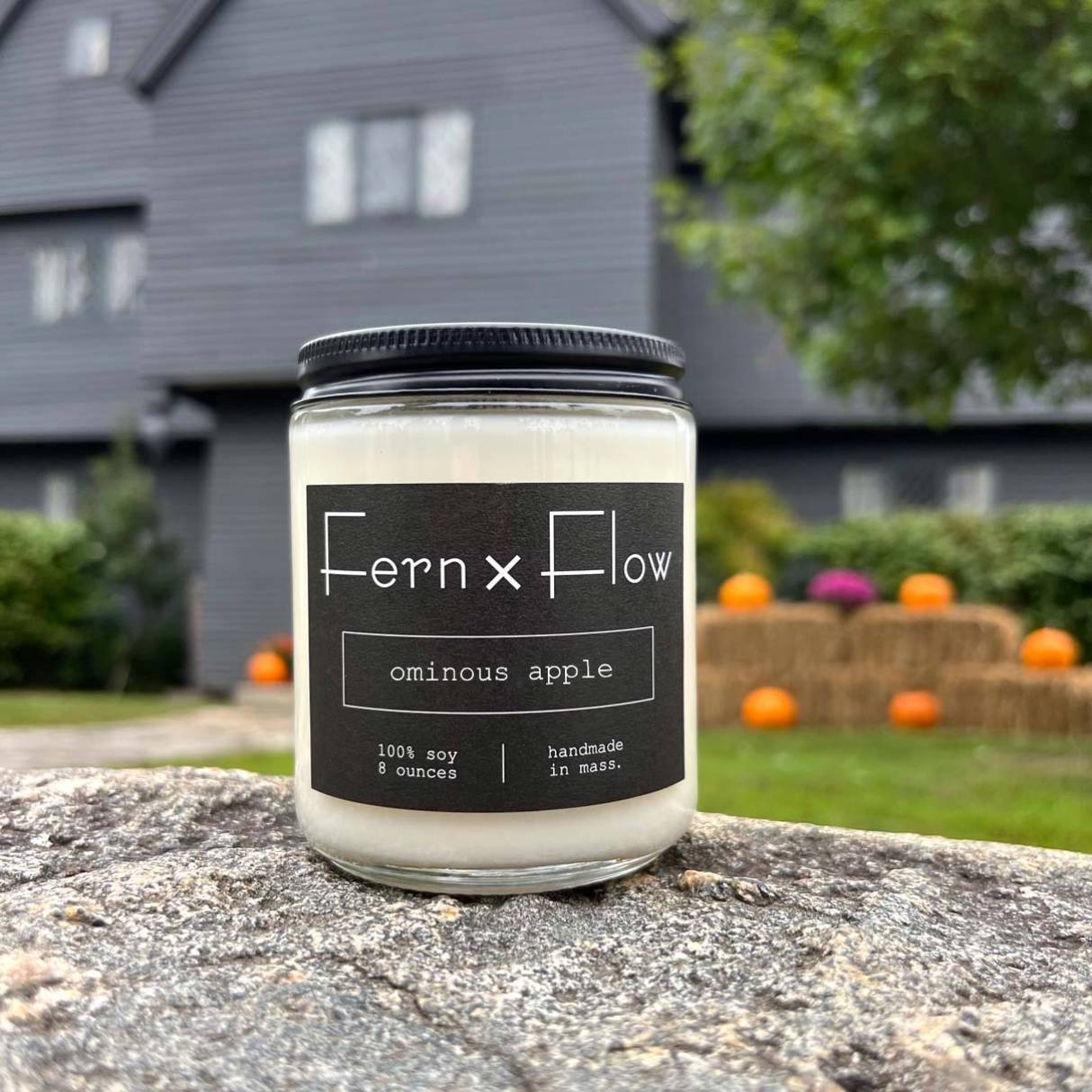 Fern x Flow Ominous Apple halloween-inspired scented soy candle in front of the Witch House in Salem, MA.